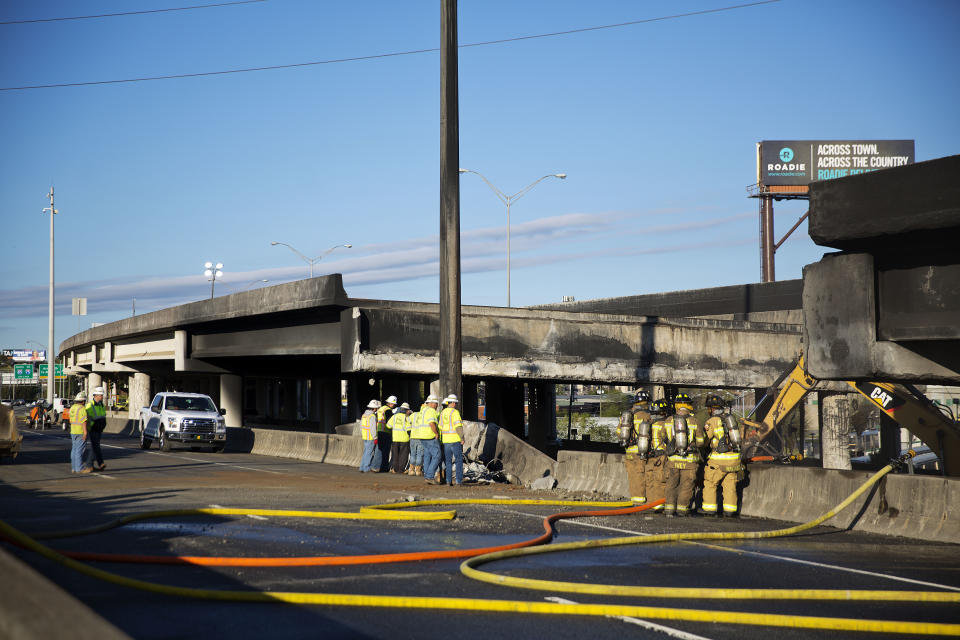 Construction workers and firefighters survey a section of an overpass that collapsed from a large fire on Interstate 85 in Atlanta, Friday, March 31, 2017. Many commuters in some of Atlanta's densely populated northern suburbs will have to find alternate routes or ride public transit for the foreseeable future after a massive fire caused a bridge on Interstate 85 to collapse Thursday, completely shutting down the heavily traveled highway. (AP Photo/David Goldman)