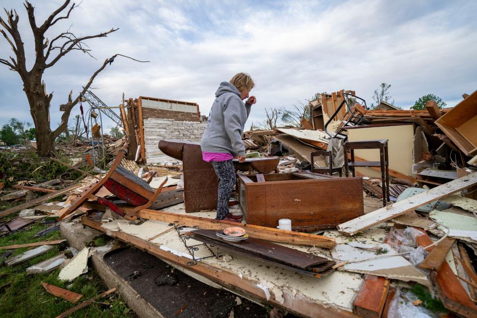 Gerry Sheriff looks for belonging at her home in Greenfield, Wednesday, May 22, 2024. Multiple residents were killed when a tornado struck the town Tuesday afternoon.