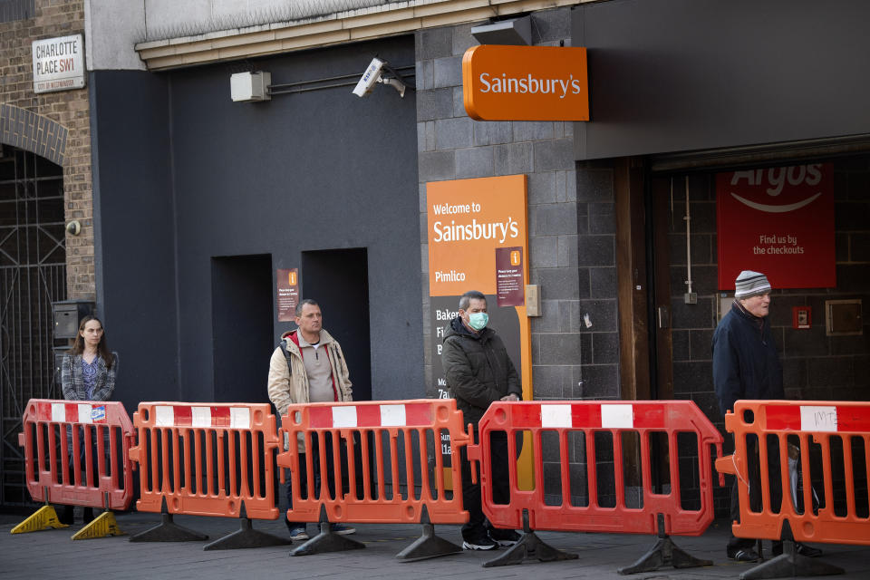 Customers queue between social distancing markers on the pavement outside a supermarket in Westminster, London after Prime Minister Boris Johnson put the UK in lockdown to help curb the spread of the coronavirus.