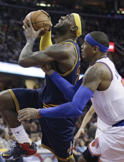 LeBron James, going to the bucket against Carmelo Anthony, likes being a power player off the court as well. (AP) 