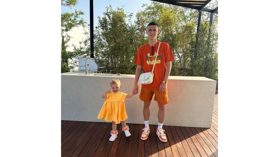 A photo of Phil Foden holding his daughter's hand 