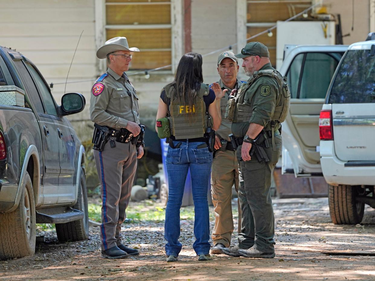 Law enforcement officials work Sunday, April 30, 2023, in the neighborhood where a mass shooting occurred Friday night, in Cleveland, Texas.