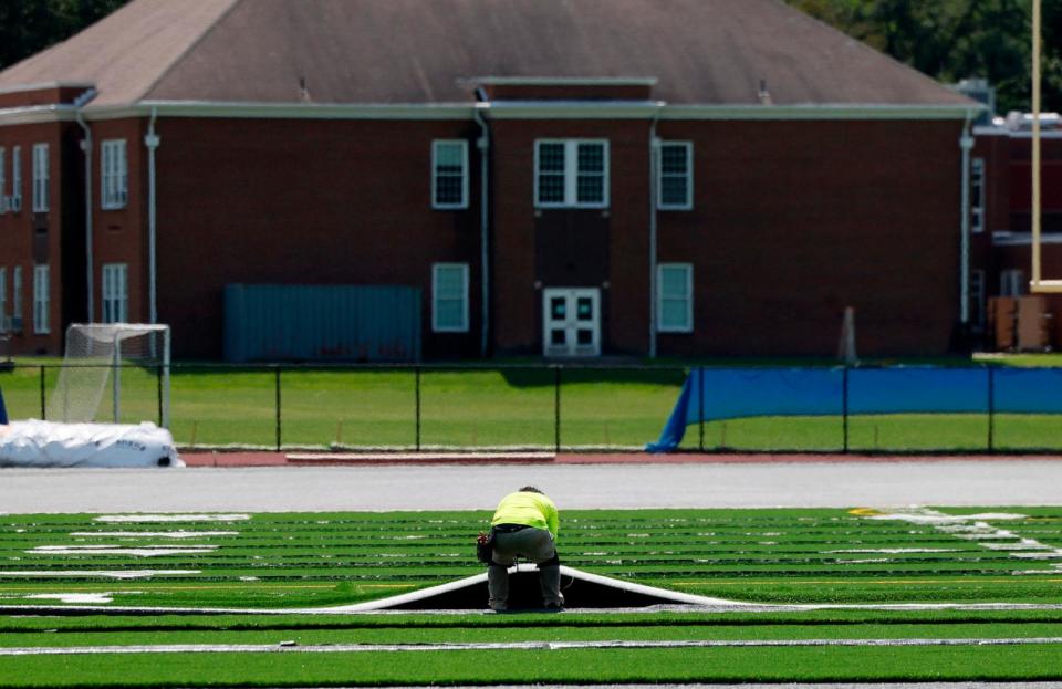 PHOTO: In this Aug. 2, 2023, file photo, a contractor works to replace artificial turf at Newton South High School in Newton, Mass.  (Boston Globe via Getty Images, FILE)