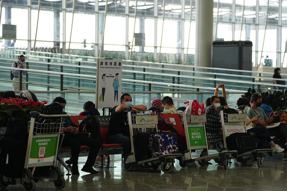 Passengers sit at the departure hall in Hong Kong international airport in Hong Kong, Friday, Sep. 23, 2022. Hong Kong’s leader announced the city would no longer require incoming travelers to quarantine in designated hotels as the city seeks to open up globally after nearly two years. The measures will come into effect Monday(AP Photo/Lam Yik)