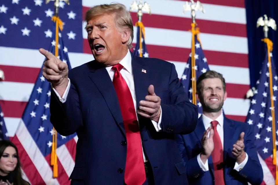 Republican presidential candidate Donald Trump points to the crowd, accompanied by his son, Eric, at a caucus night party in Des Moines, Iowa, Monday, Jan. 15, 2024. (AP Photo/Andrew Harnik) ORG XMIT: PNA310