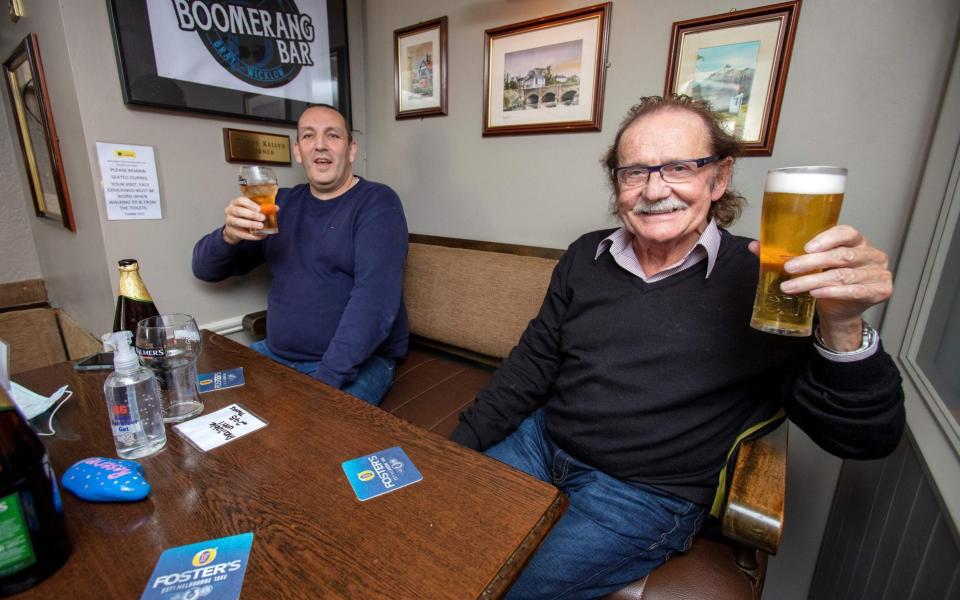 People enjoy a drink at the re-opened Boomerang Bar, a so-called 'wet bar', where only drinks, not food, are served, in Bray, eastern Ireland - AFP