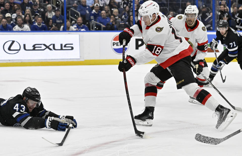 Ottawa Senators center Tim Stutzle (18) scores as Tampa Bay Lightning defenseman Darren Raddysh (43) dives during the first period of an NHL hockey game, Monday, Feb. 19, 2024, in Tampa, Fla. (AP Photo/Jason Behnken)