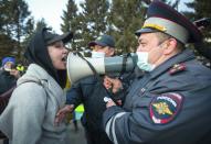 A woman argues with police officer during a protest in support of jailed opposition leader Alexei Navalny in Ulan-Ude, the regional capital of Buryatia, a region near the Russia-Mongolia border, Russia, Wednesday, April 21, 2021. Navalny's team has called for nationwide protests on Wednesday following reports that the politician's health was deteriorating in prison, where he has been on hunger strike since March 31. Russian authorities have stressed that the demonstrations were not authorized and warned against participating in them. (AP Photo/Anna Ogorodnik)