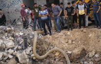 Sewage water is drawn from the crater where the home of Ramez al-Masri was destroyed by an air-strike prior to a cease-fire reached after an 11-day war between Gaza's Hamas rulers and Israel, Sunday, May 23, 2021, in Beit Hanoun, the northern Gaza Strip. (AP Photo/John Minchillo)