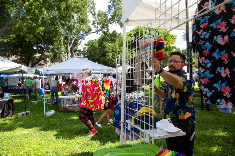 John Murillo of ProudAF Boutique in Miami sets out merchandise during the 4th Annual Naples Pride Fest, Saturday, July 9, 2022, at Cambier Park in Naples, Fla.