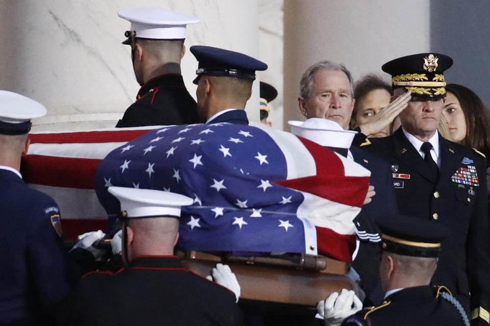 Former President George W. Bush watches as the flag-draped casket of his father, former President George H.W. Bush is carried by a joint services military honor guard to lie in state in the rotunda of the U.S. Capitol, Monday, Dec. 3, 2018, in Washington. (AP Photo/Alex Brandon, Pool)