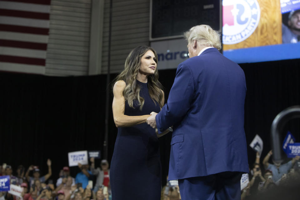 FILE - Former President Donald Trump greets South Dakota Gov. Kristi Noem at the South Dakota Republican Party Monumental Leaders rally Friday, Sept. 8, 2023, in Rapid City, S.D. A South Dakota tribe has banned Noem from the Pine Ridge Reservation after she spoke this week about wanting to send razor wire and security personnel to Texas to help deter immigration at the U.S.-Mexico border and also said cartels are infiltrating the state's reservations. (AP Photo/Toby Brusseau, File)