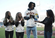 This photo provided by the CalHope Courage Award shows Kristi Yamaguchi, right, presenting twins Amaya and Anysa Gray, and Nigel Wilson with the CalHope Courage Award before a baseball game between the San Francisco Giants and Washington Nationals on Tuesday, May 9, 2023, at Oracle Park in San Francisco.(Daniel Moebus-Bowles/CalHope Courage Award via AP)
