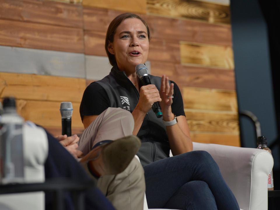 Natalie Coughlin today with a microphone in her hand sitting in a chair