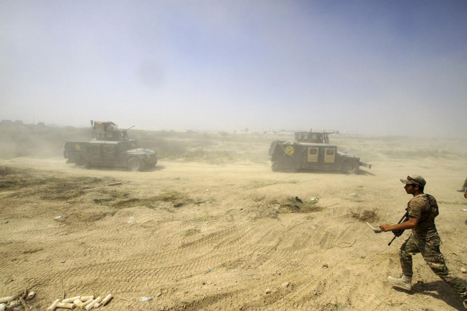 FILE - In this June 15, 2016, file photo, Iraqi security forces advance their positions during the fight against Islamic State militants in Fallujah, Iraq. The U.S. launched its invasion of Iraq on March 20, 2003, unleashing a war that led to an insurgency, sectarian violence and tens of thousands of deaths. (AP Photo/Anmar Khalil, File)