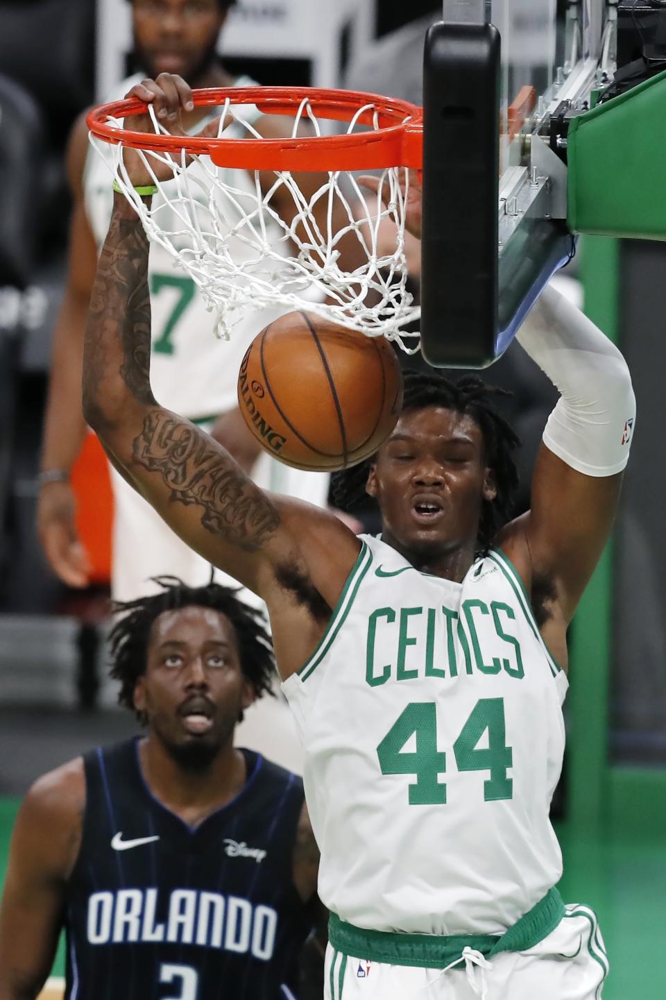 Boston Celtics' Robert Williams III (44) dunks in front of Orlando Magic's Al-Farouq Aminu during the first half of an NBA basketball game, Sunday, March 21, 2021, in Boston. (AP Photo/Michael Dwyer)