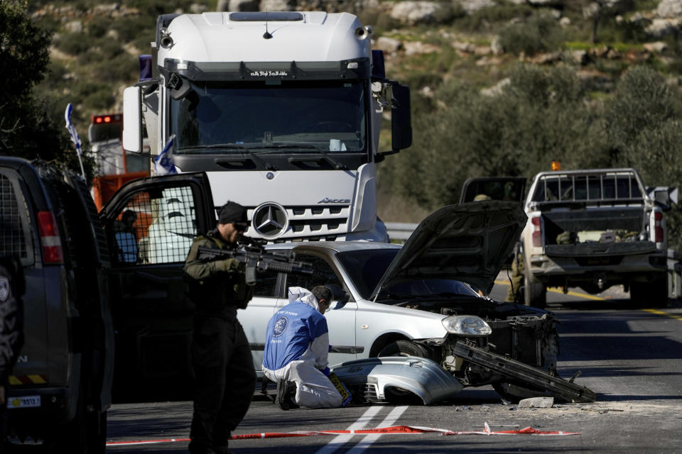 Israeli security forces examine the scene of a Palestinian shooting attack, near Wadi al-Haramiya, West Bank, Sunday, Jan. 7, 2024. A Palestinian resident of Jerusalem who presumably was mistaken by the assailants as an Israeli because of the Israeli car license plates was fatally shot in the shooting, the Magen David Adom rescue service said. (AP Photo/Leo Correa)