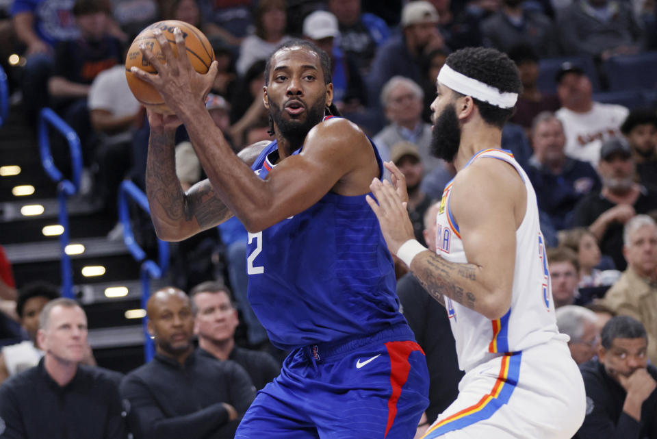 Los Angeles Clippers forward Kawhi Leonard (2) holds the ball as Oklahoma City Thunder forward Kenrich Williams (34) defends during the second half of an NBA basketball game, Thursday, Feb. 22, 2024, in Oklahoma City. (AP Photo/Nate Billings)