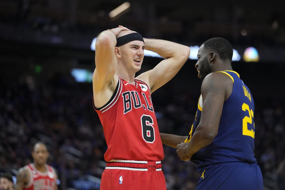 Chicago Bulls guard Alex Caruso (6) reacts next to Golden State Warriors Draymond Green during the first half of the team's NBA basketball game in San Francisco, Friday, Dec. 2, 2022. (AP Photo/Godofredo A. Vásquez)