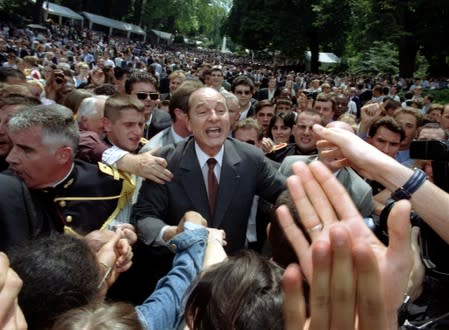 FILE PHOTO: French President Jacques Chirac (C) greets members of the public invited to the traditional garden p..