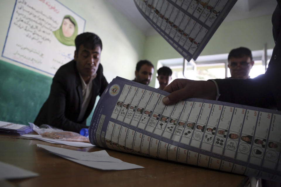 Afghan election workers count ballots during the parliamentary elections, at a polling station in Kabul, Afghanistan, Sunday, Oct. 21, 2018. The elections entered a second day after delays caused by violence and technical issues, as a roadside bomb killed nearly a dozen civilians on Sunday, including several children. (AP Photo/Rahmat Gul)