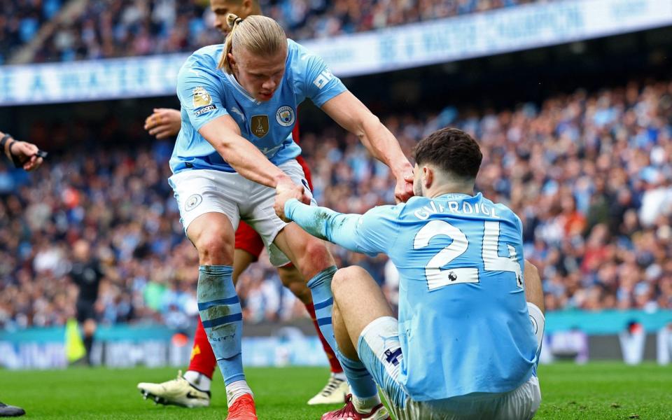 Manchester City's Erling Braut Haaland helps up Josko Gvardiol