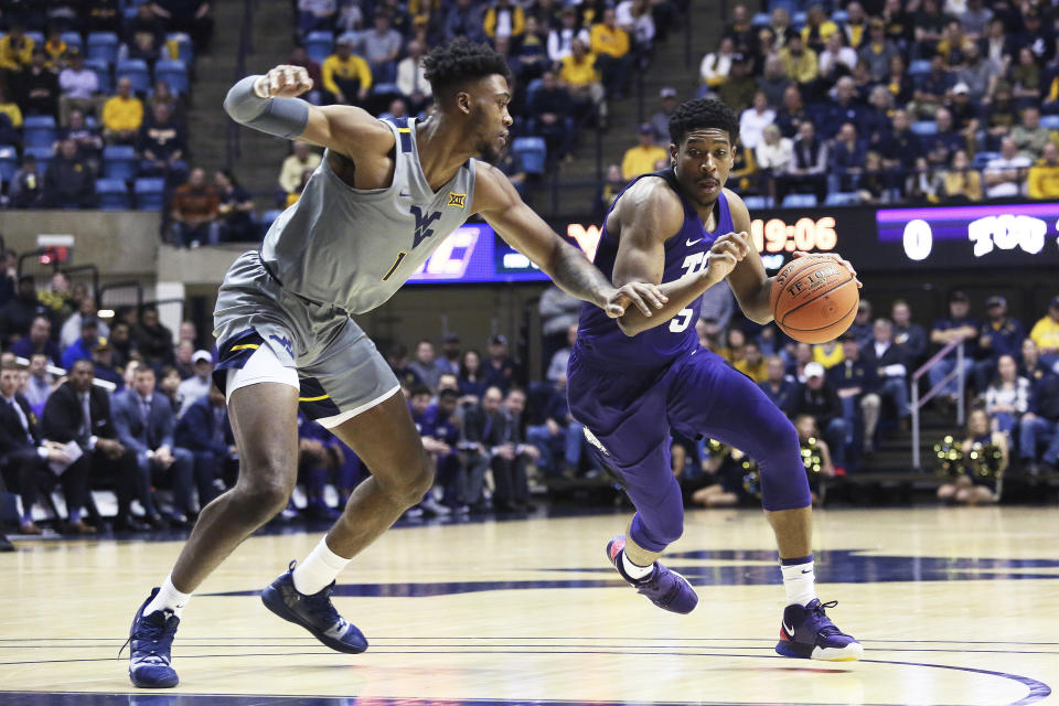 TCU guard Jaire Grayer (5) is defended by West Virginia forward Derek Culver during the first half of an NCAA college basketball game Tuesday, Jan. 14, 2020, in Morgantown, W.Va. (AP Photo/Kathleen Batten)