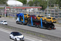 A truck carries new cars on the motorway leading to Paris, Tuesday, May 26, 2020 in Villacoublay, west of Paris. French President Emmanuel Macron is set to unveil on Tuesday new measures to rescue the country's car industry, which has been hammered by the virus lockdown and the resulting recession. The issue is politically sensitive, since France is proud of its auto industry, which employs 400,000 people in the country and is a big part of its manufacturing sector. (AP Photo/Michel Euler)