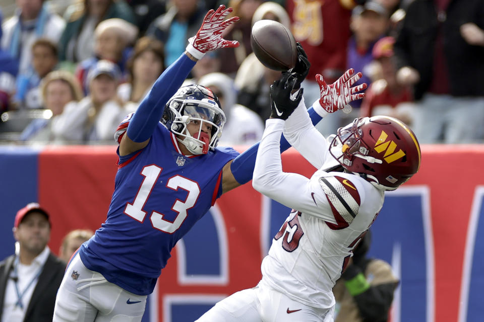 New York Giants wide receiver Jalin Hyatt (13) prevents an interception by Washington Commanders safety Percy Butler (35) during the second quarter of an NFL football game, Sunday, Oct. 22, 2023, in East Rutherford, N.J. (AP Photo/Adam Hunger)