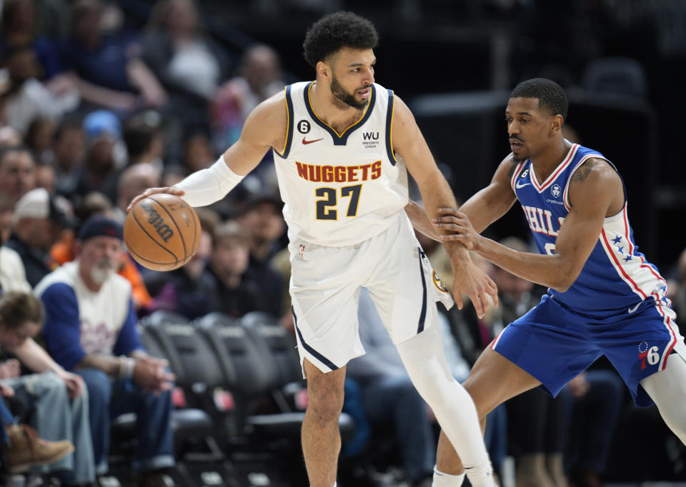 Denver Nuggets guard Jamal Murray, left, looks to pass the ball as Philadelphia 76ers guard De'Anthony Melton defends in the first half of an NBA basketball game Monday, March 27, 2023, in Denver. (AP Photo/David Zalubowski)