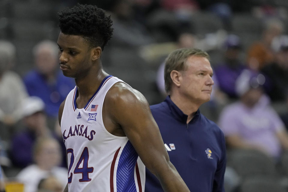 Kansas forward K.J. Adams Jr. walks past head coach Bill Self as he comes out of the game during the second half of an NCAA college basketball game against Cincinnati Wednesday, March 13, 2024, in Kansas City, Mo. Cincinnati won 72-52. (AP Photo/Charlie Riedel)