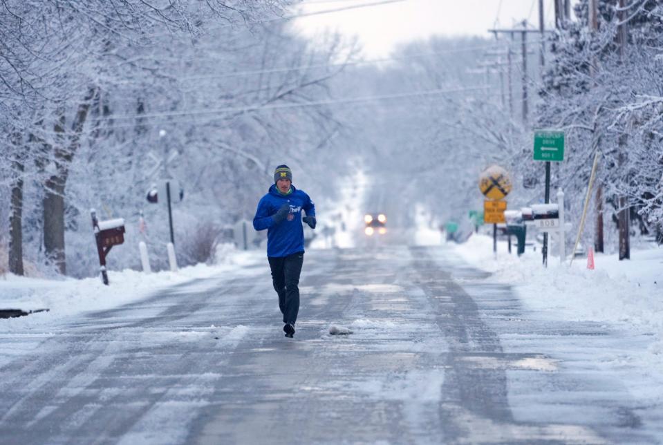 Ryan Lovitz, of Fox Point, runs along East Dean Road after a snowfall in Fox Point on Thursday, Feb. 15, 2024. The area saw 2 to 3 inches of snow that fell overnight into Thursday.