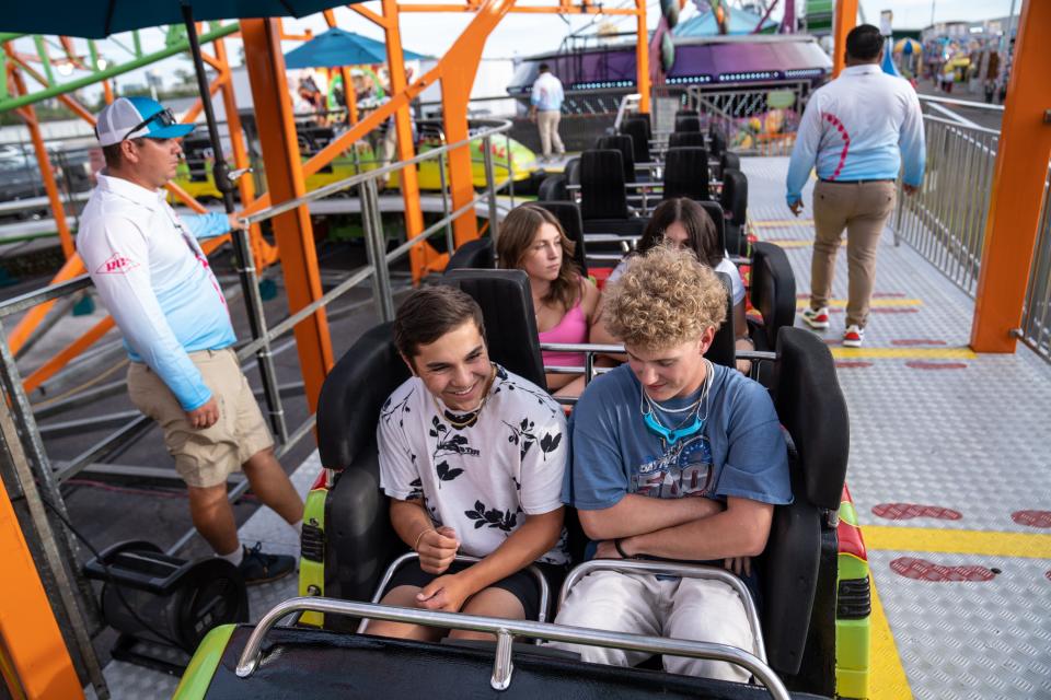 Matthew Ortiz (left), 19, and Zeke Rose, 17, ride a rollercoaster at the Arizona State Fair in Phoenix on Sept. 22, 2023.