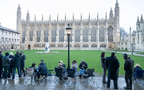 People queue for the Festival of Nine Lessons and Carols at King's College Cambridge just after dawn 24th December 2013. Some slept overnight to get a good place in the queue. - Credit: Julian Eales/Alamy
