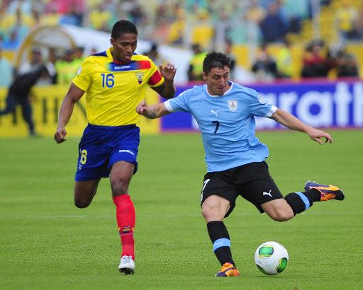 El volante uruguayo Cristian Rodríguez se apresta a rematar frente a su par de Ecuador Antonio Valencia en partido de las eliminatorias sudamericanas al Mundial 2014 en Quito, el 11 de octubre de 2013. (AFP | Juan Cevallos)