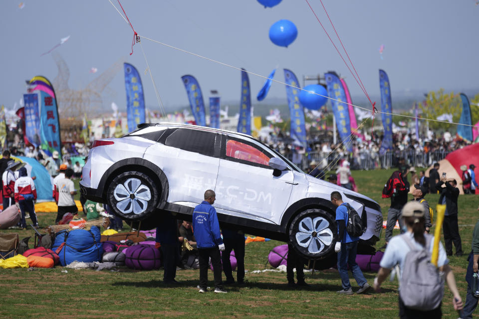 A car-shaped kite prepares to lift at the 41st International Kite Festival in Weifang, Shandong Province of China, Saturday, April 20, 2024. (AP Photo/Tatan Syuflana)