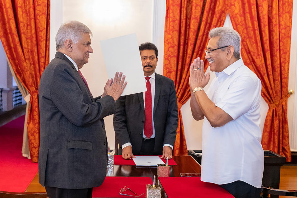 FILE- In this photograph provided by the Sri Lankan President's Office, President Gotabaya Rajapaksa, right, greets prime minister Ranil Wickremesinghe during the latter's oath taking ceremony as the new finance minister in Colombo, Sri Lanka, May 25, 2022. Both men Saturday said they would resign, after the country’s most chaotic day in months of political turmoil, with protesters storming both officials’ homes and setting fire to one of the buildings in a rage over the nation’s severe economic crisis. (Sri Lankan President's Office via AP)