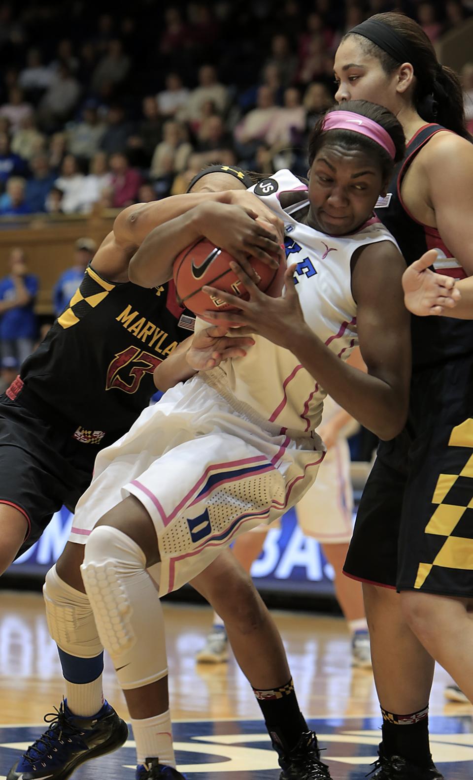 Duke's Elizabeth Williams, center, secures a loose ball between Maryland's Alicia DeVaughn, left, and Brionna Jones, right, during the first half of an NCAA college basketball game in Durham, N.C., Monday, Feb. 17, 2014. Duke led at halftime 38-31. (AP Photo/Ted Richardson)