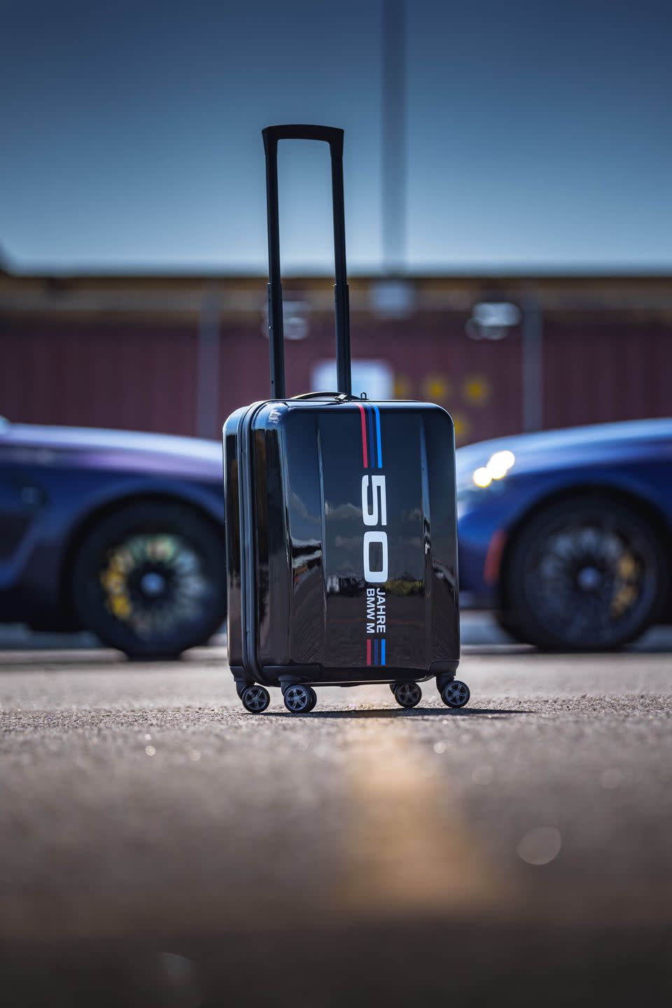 <p>No package made specifically for M diehards would be complete without a bit of branded swag, so there's also a roller suitcase included with the purchase of the special M3 that has the same "50 Jahre" logo and red and blue stripes.</p>