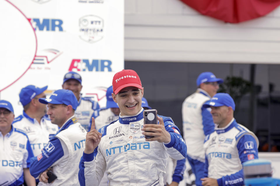 Alex Palou celebrates with his phone in the Winner's Circle after an IndyCar race at Road America in Elkhart Lake, Wisc., Sunday, June 20, 2021. (AP Photo/Jeffrey Phelps)