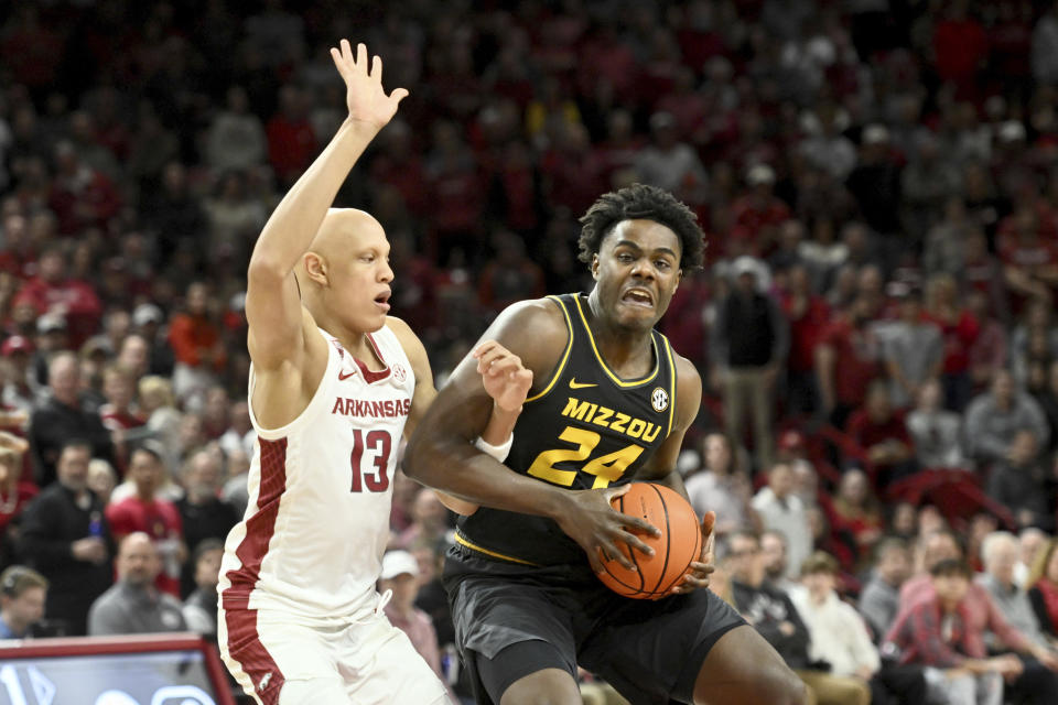 Missouri guard Kobe Brown (24) tries to get past Arkansas guard Jordan Walsh (13) as he drives to the basket during the first half of an NCAA college basketball game Wednesday, Jan. 4, 2023, in Fayetteville, Ark. (AP Photo/Michael Woods)