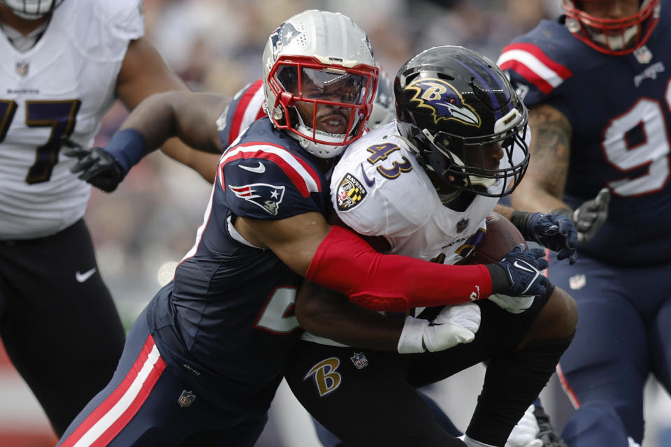 New England Patriots safety Adrian Phillips, left, tackles Baltimore Ravens running back Justice Hill, right, in the first half of an NFL football game, Sunday, Sept. 25, 2022, in Foxborough, Mass. (AP Photo/Michael Dwyer)