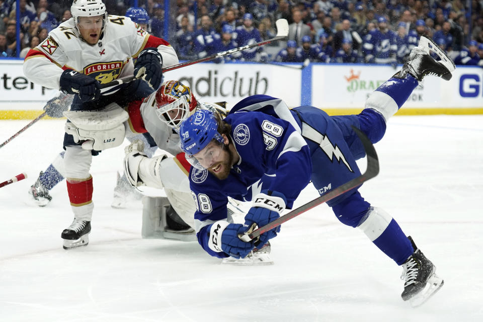 Tampa Bay Lightning left wing Brandon Hagel (38) goes down after crashing into Florida Panthers goaltender Sergei Bobrovsky (72) and defenseman Gustav Forsling (42) during the second period in Game 3 of an NHL hockey second-round playoff series Sunday, May 22, 2022, in Tampa, Fla. (AP Photo/Chris O'Meara)