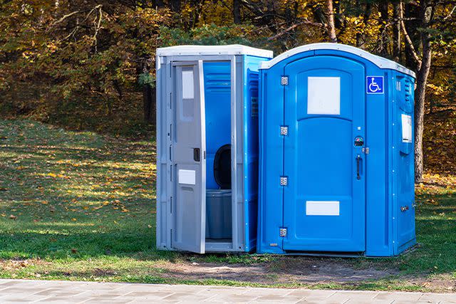 <p>Getty</p> Two portable toilets in a park.