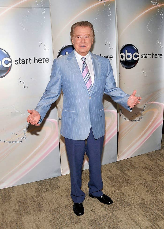 Regis Philbin in a striped suit, standing with arms open, at an ABC event