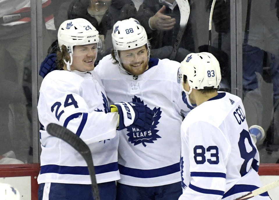 Toronto Maple Leafs right wing William Nylander (88) celebrates his winning goal in overtime with Kasperi Kapanen (24) and Cody Ceci (83) in an NHL hockey game against the New Jersey Devils, Friday, Dec. 27, 2019, in Newark, N.J. (AP Photo/Bill Kostroun)