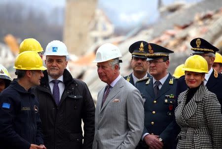 Britain's Prince Charles speaks with an Italy's Civil Protection agency member during his visit to the town of Amatrice, which was levelled after an earthquake last year, in central Italy April 2, 2017. REUTERS/Alessandro Bianchi