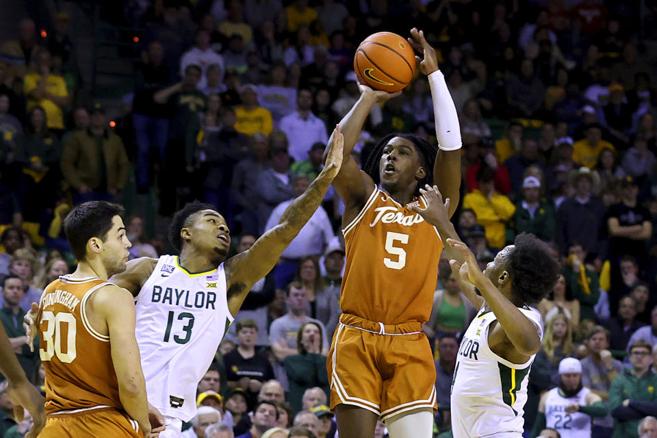 Texas guard Marcus Carr (5) shoots over Baylor guard Langston Love (13) and Baylor guard LJ Cryer during the first half of an NCAA college basketball game Saturday, Feb. 25, 2023, in Waco, Texas. (AP Photo/Jerry Larson)
