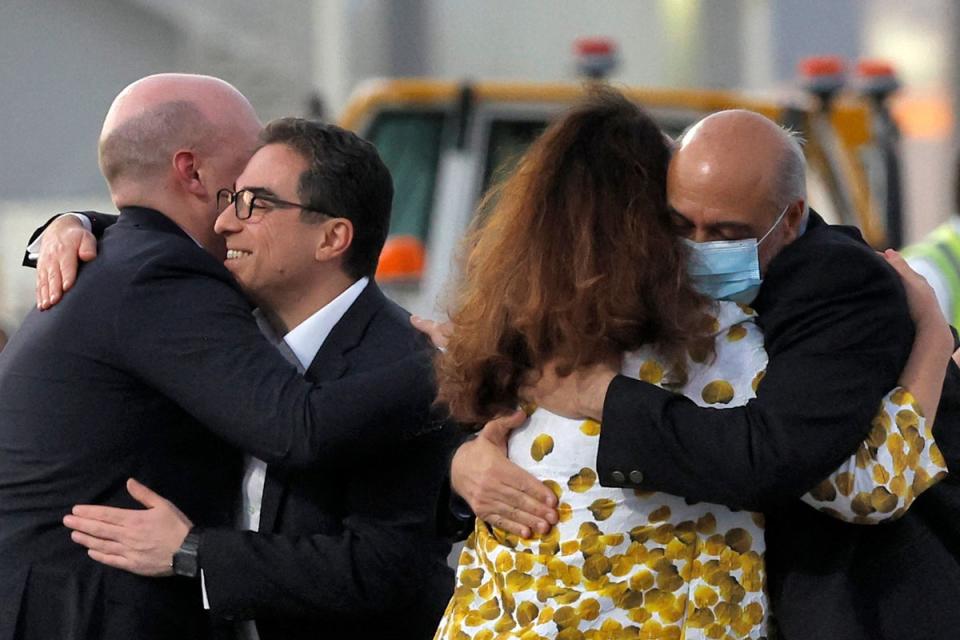Mr Tahbaz (right, wearing mask) is welcomed on the tarmac at Doha airport after his release from Iran (AFP via Getty Images)