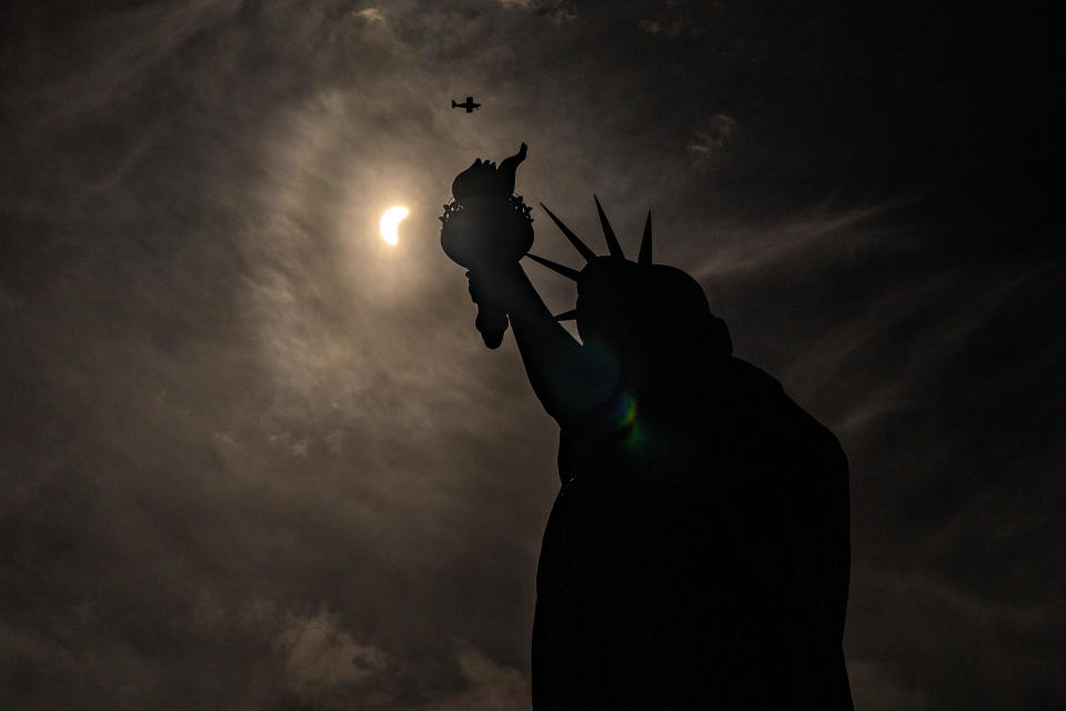 The Statue of Liberty is seen during a partial solar eclipse, where the moon partially blots out the sun, at Liberty Island in New York City, April 8, 2024. / Credit: David Dee Delgado / REUTERS